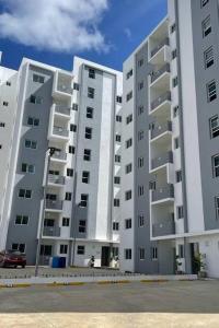 dwa duże białe budynki apartamentowe z parkingiem w obiekcie 7F apartamento 3hab piscina ascensor y area social w mieście Santiago de los Caballeros