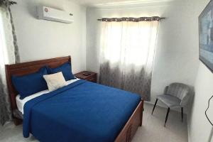 a bedroom with a blue bed and a chair at 7F apartamento 3hab piscina ascensor y area social in Santiago de los Caballeros