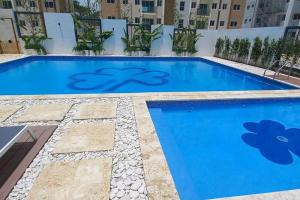 basen z niebieską wodą w budynku w obiekcie 7F apartamento 3hab piscina ascensor y area social w mieście Santiago de los Caballeros