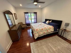 een slaapkamer met een bed, een spiegel en een dressoir bij NEW 3 bedroom - Thoroughbred Farm & Lake Views! in Saratoga Springs