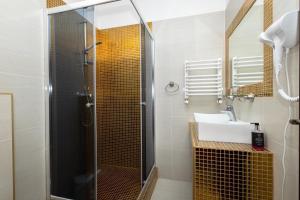 een badkamer met een douche en een wastafel bij Penzion Velky Meder in Dunajská Streda