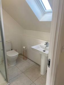 a bathroom with a toilet and a sink at Agase Way - Stylish 4 Bed Home in Milton Keynes