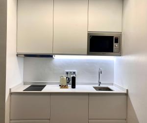 cocina con fregadero y microondas en Marina Walk Apartment, en Vilamoura