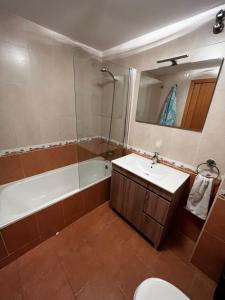 y baño con bañera, lavabo y aseo. en Apartamento en Boiro en Escarabote