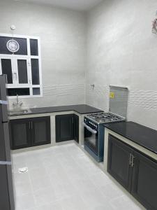 a kitchen with a stove and a sink in it at شقق مفروشة للايجار صلالة - صحلنوت New Furnished Apartments for rent Salalah - Sahalnout in Sikun Shikfainot