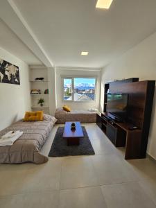 uma sala de estar com um sofá e uma televisão de ecrã plano em Xalpen Ushuaia em Ushuaia