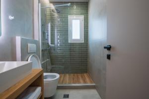 a bathroom with a toilet and a glass shower at Palaia Luxury Suite in Volos