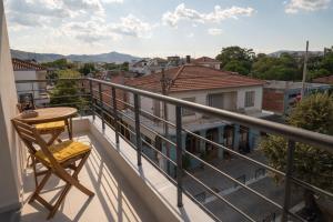 balcón con mesa y vistas a la ciudad en Palaia Luxury Suite, en Volos