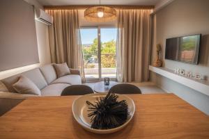 sala de estar con mesa y sofá en Palaia Luxury Suite, en Volos