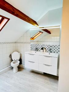 La salle de bains blanche est pourvue de toilettes et d'un lavabo. dans l'établissement Jabeen's House Bedroom 2, à Bezons