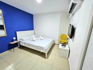 1 dormitorio con cama blanca y pared azul en סוויטת מרלו - Merlot Suite, en Eilat