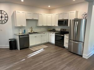 a kitchen with white cabinets and stainless steel appliances at NEW 3 bedroom - Thoroughbred Farm & Lake Views! in Saratoga Springs