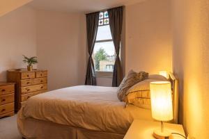 a bedroom with a bed and a window at Abeville Village Apartment in London