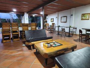 una sala de estar con sofás, mesas y sillas en HOSTERÍA BRISAS DEL RÍO, en Marinilla