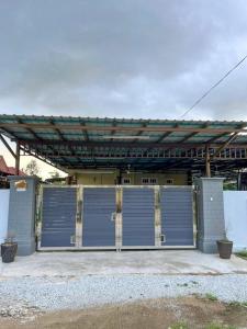 a garage with a large blue garage door at Homestay Seri Aman Pasir Puteh 