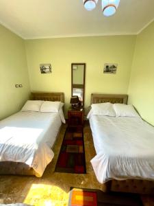 a bedroom with two beds and a mirror in it at Sphinx palace pyramids view in Cairo