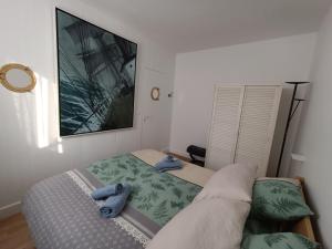 a bedroom with a bed with two blue towels on it at Chez Mamarina - Quadruplex - Marina Deauville in Deauville