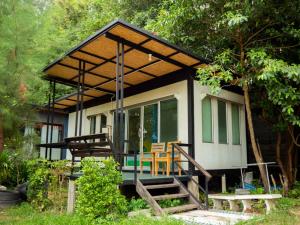 een klein huis met een veranda en een patio bij Beach Box Resort at Rimlay Rayong in Rayong