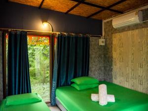a green bed in a room with a window at Beach Box Resort at Rimlay Rayong in Rayong