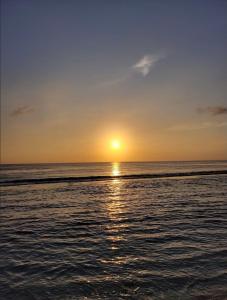 a sunset over the ocean with the sun setting at DESILA Beach House in Nusa Penida