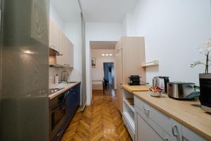 uma cozinha com armários brancos e piso em madeira em Napwell em Graz
