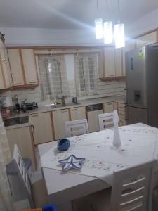 a kitchen with a white table and a refrigerator at platamon 3 platania in Platamonas
