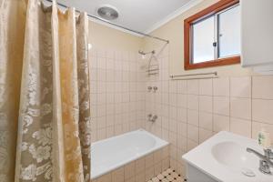 a bathroom with a shower curtain and a sink at Clare Valley Cabins in Clare