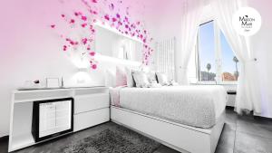 a white bedroom with pink flowers on the wall at B&B Maison Mari in Naples