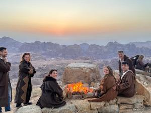 瓦迪穆薩的住宿－Petra Desert Dream Hotel，一群人围坐在 ⁇ 火旁