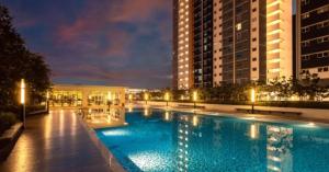 a large swimming pool in a city at night at La Suite@Alanis Residence in Sepang