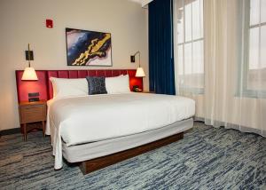 a hotel room with a large bed and a window at BLU-Tique, Akron, a Tribute Portfolio Hotel in Akron