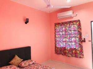 a bedroom with a flower curtain and a bed at Chalet Sri Bayu in Kampong Balai Maras