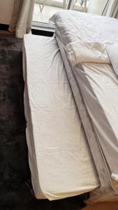 an unmade bed with white sheets on the floor at Condo in Manila