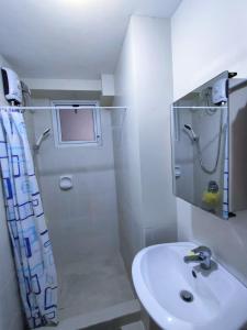 a white bathroom with a sink and a shower at Condo in Manila