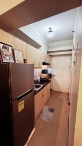 a kitchen with a refrigerator and a sink in it at Condo in Manila