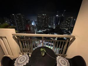 a table and chairs on a balcony at night at Condo in Manila