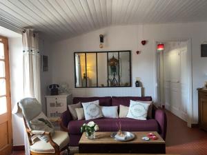 een woonkamer met een paarse bank en een tafel bij Maison Angles , 2 pièces, 2 personnes - FR-1-336-83 in Angles