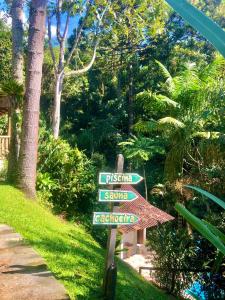 un letrero de la calle en el césped junto a un jardín en Casa Bella Ana en Visconde De Maua