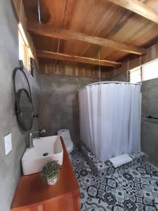 uma casa de banho com um lavatório e um chuveiro com um WC. em Cabaña Tribu 