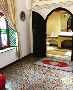 Zimmer mit einem Bad mit einer Tür und einem Spiegel in der Unterkunft Riad A La Belle Etoile in Salé