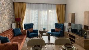un soggiorno con divano e sedie blu di شقة سياحية فندقية بمنطقة بشاك شهير بمجمع ميدكولية a Istanbul