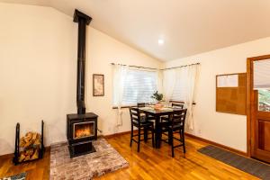 a living room with a table and a wood stove at Nature's Nook - Blissful Cabin in the Woods in Placerville