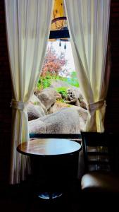 una mesa y una ventana con una cortina en Da Let House & Coffee, 