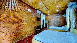 a brick room with a bed and a brick wall at Da Let House & Coffee 