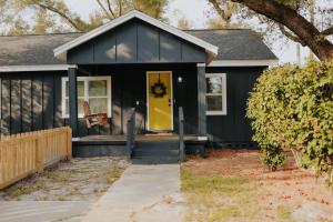 a black house with a yellow door at Dream On – Style & Comfort Near Historic Downtown in Panama City