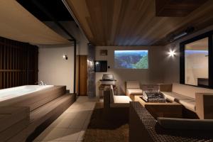 a bathroom with a tub and a tv on the wall at villa vacances hamanako in Hamamatsu