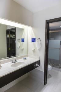 a bathroom with a sink and a toilet and a mirror at Best Western Hotel Plaza Matamoros in Matamoros