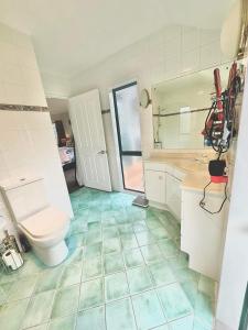 y baño con aseo, lavabo y espejo. en Observation Guest Suite, en Paraparaumu