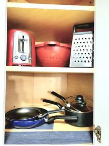 a kitchen shelf with pots and pans and a stove at White Mountain Barn in Littleton