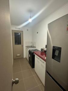 a kitchen with a refrigerator and a red counter top at Apartamento Central Quillota con estacionamiento in Quillota